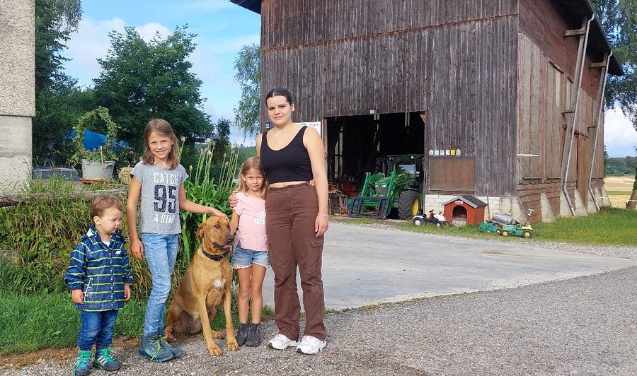 Anaïs mit den Kindern und dem Hund der Familie Hänni auf deren Grundstück. Bild: zVg