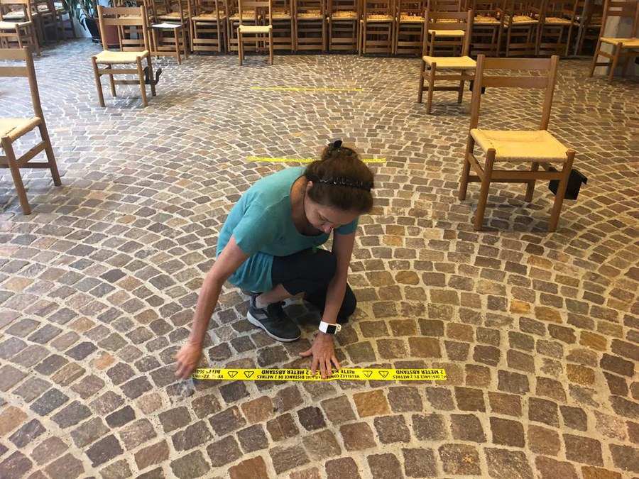 Sakristanin Yazmín Homberger  klebt Abstände in der Klotener Kirche.
