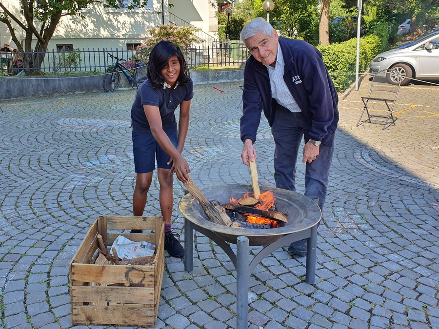 Der Thalwiler Sigrist Erwin Aschwanden entzündet, unterstützt von einem Ministranten, das Pfingstfeuer.
