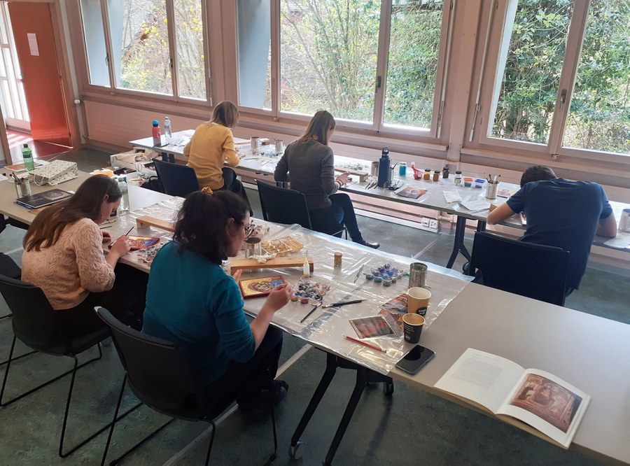 Teilnehmende eines bereits stattgefundenen Workshops beim Malen ihrer Ikonen.