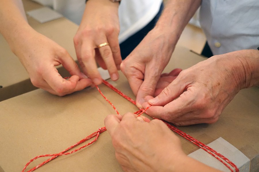 Vielhändig werden die  Schachteln mit Akten verschnürt...