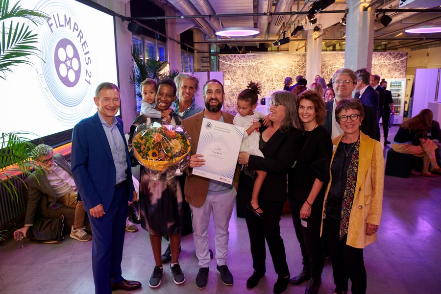 Filmjury der Kirchen mit Regisseur, Familie und Kameramann: Kirchenrat Andrea Marco Bianca, Rebecca Baillif, Kameramann Joseph Areddy, Regisseur Fred Baillif mit Preisurkunde, Marietherese Mäder, Karin Heberlein, Synodalrat Tobias Grimbacher und Jurypräsidentin Lucie Bader (von links)