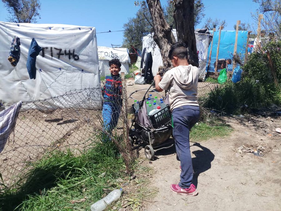 Kinder transportieren Wasser im Lager.