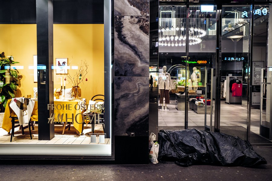 Die Pandemie verschärft die Kluft in der reichen Schweiz: Schutz- und wärmesuchend übernachtet ein randständiger Mensch an der Bahnhofstrasse in Zürich vor goldschimmernden Schaufenstern. Frohe Ostern!