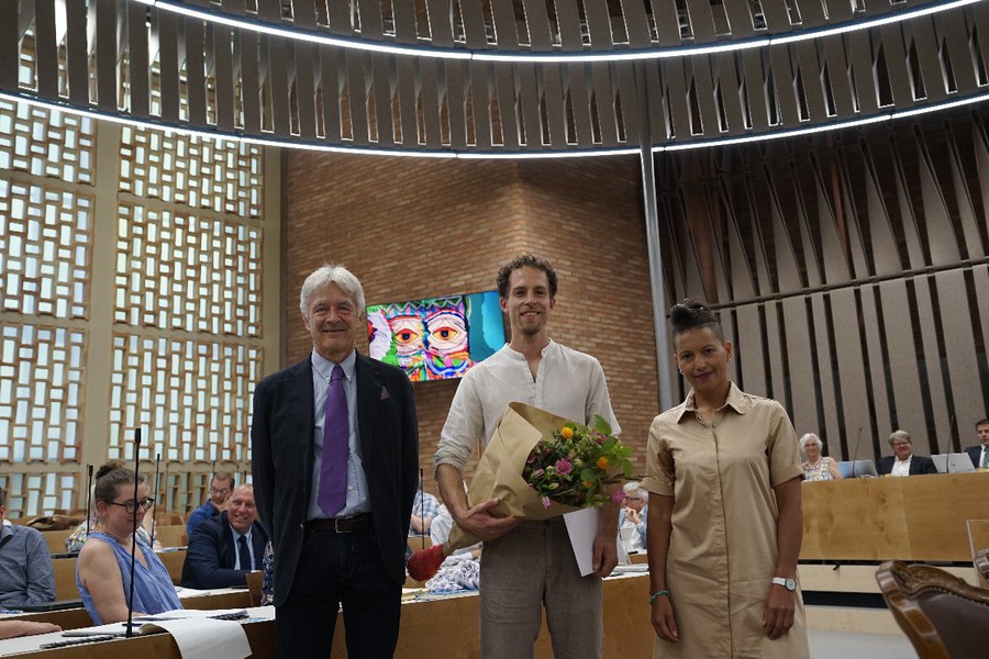 Martin Wöllenstein erhält den Sonderpreis Kunst und Ethik von Daniel Otth (l.) und Dr. Dana Sindermann (r.), im Hintergrund zu sehen die Kunstinstallation. Foto: Leonie Maurer Preisübergabe Martin Wöllenstein (mitte).JPG