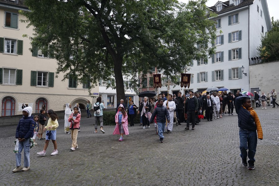 Ankunft der Prozession am Zürcher Grossmünster. In der Kirche warten schon weitere Gäste, die sich Wetter und Weg heute erspart haben.